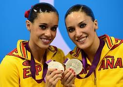 Ona Carbonell (i) y Andrea Fuentes muestran la medalla de plata lograda en Londres 2012. / Efe