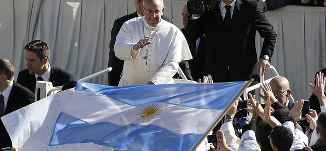 El Papa saluda a un grupo de simpatizantes con la bandera argentina en la Plaza de San Pedro. / Reuters