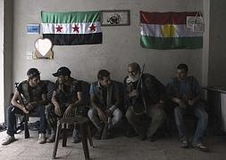 Miembros del Ejército Libre de Siria (i), conversan con guerrilleros kurdos en Aleppo. / Archivo