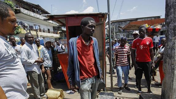 Un hombre, posible paciente de Ébola, es conducido a una ambulancia para el tratamiento de la enfermedad en Liberia 