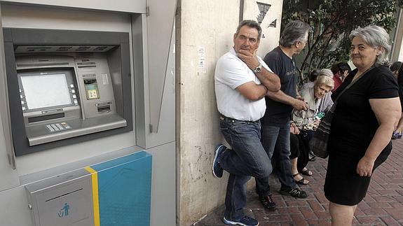 Ciudadanos griegos hacen cola para sacar dinero. 