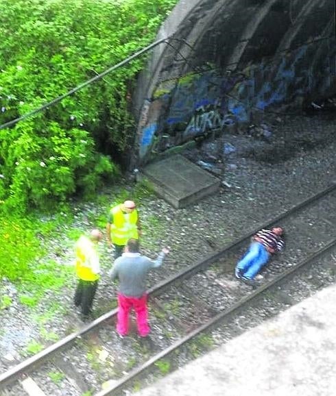 El hombre, tirado en la vía.