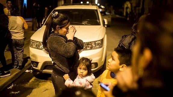 Una niña se agarra a su madre en Santiago de Chile tras el terremoto.