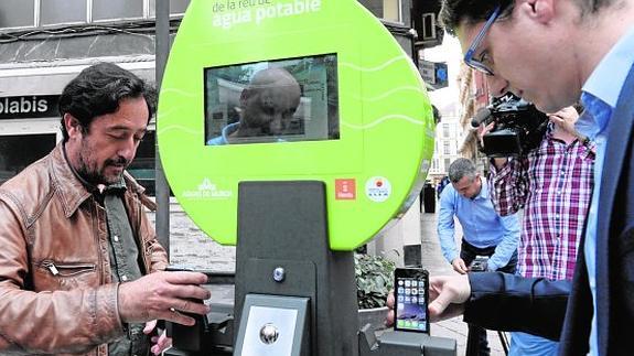 Dos ciudadanos cargan sus móviles en el punto de la plaza Cetina.