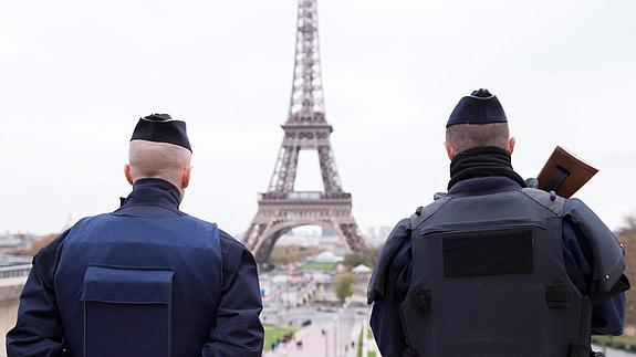 Dos policías franceses patrullan ante la Torre Eiffel.