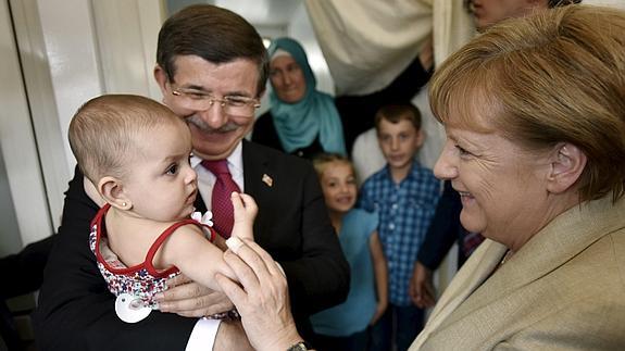 Angela Merkel y Ahmet Davutoglu visitan a una familia de refugiados en el campo de Nizip 2, en Gaziantep.