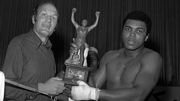 Muhammad Ali (d), con uno de sus trofeos. 