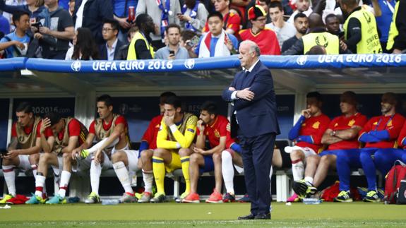 Del Bosque, serio, con el banquillo español detrás.