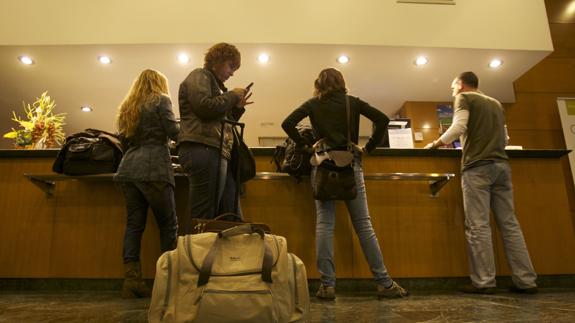 Turistas en la recepción de un hotel. 