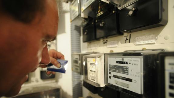 Un operario analiza varios contadores de consumo eléctrico.
