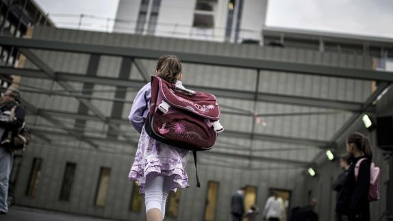 Una niña entrando a un colegio.  
