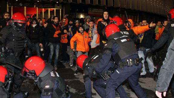 Ertzainas tratan de contener a los ultras del Apoel en San Mamés. 