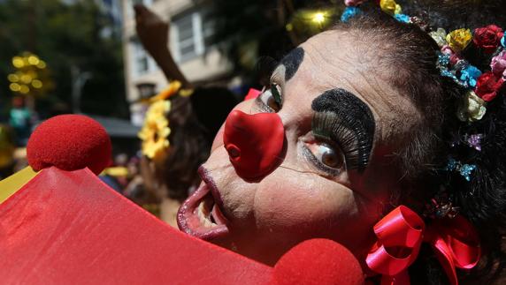 Una mujer disfrazada de payaso participa en el desfile de la comparsa Gigantes de Lira. 