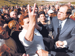 Una vecina hace la señal de victoria entre las autoridades que inauguraron el puente de Manzanal. / M. A. MONTESINOS