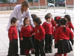 Una profesora del Allúe Morer con varios de los alumnos del colegio ataviados con su uniforme. / RAMÓN GÓMEZ