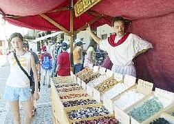 Un vendedor con ropas de la época ofrece sus productos
