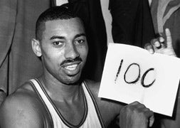 Wilt Chamberlain muestra un cartel con la cifra de 100 puntos que marco.