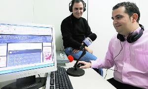 Julián Díaz Bajo, al fondo, y Diego Arias Madero muestran su web. / G. Villamil