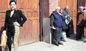 Aficionados a los toros observan a una de las jóvenes modelos antes de entrar en la plaza. / F. de la calle