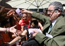 Pedro García 'El Peque' reparte billetes de 500 euros en la calle Las Parras durante el popular mercadillo de las fiestas de Cuéllar. / Mónica Rico