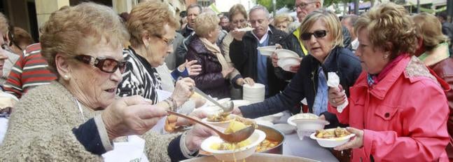 Una ama de casa reparte patatas con costillas. / Antonio Quintero