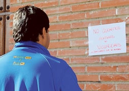 Un vecino observa uno de los carteles que han aparecido en las paredes de las casas de Honcalada. / P. G.