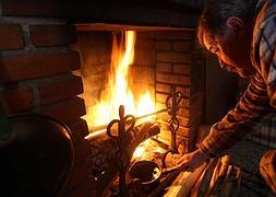 Loredo atiza los leños en la pequña chimenea de su casa. M. Chacón-Ical