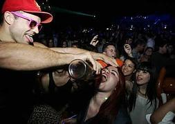 Una persona da de beber alcohol desde una botella a una joven durante una fiesta. / Almeida