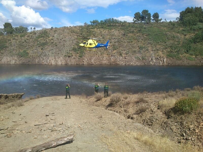 Un helicóptero y miembros de la Guarcia Civil buscan a los desaparecidos junto al pantano de Irueña.