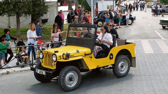 Varias personas observan a los coches clásicos en el recorrido por las calles. 