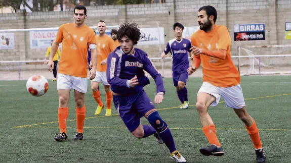 Javichi corre tras el balón seguido por Álex en un partido del Cristo contra el Unami. 