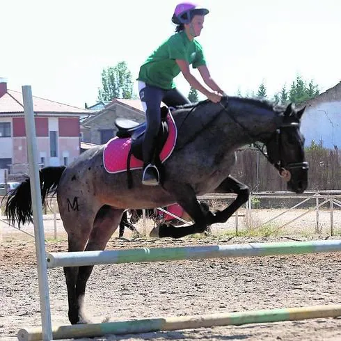 Una alumna reaiza un salto en el campamento.