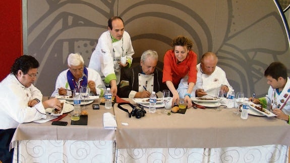 Los miembros del jurado prueban y puntúan uno de los platos, junto al coordinador del concurso (de pie).Nuria Estalayo