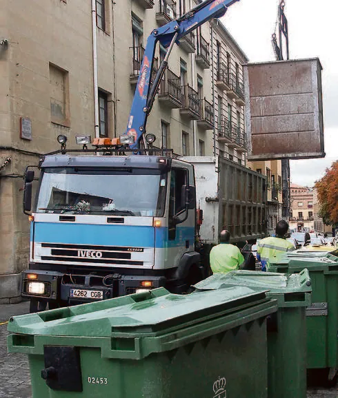 Dos operarios de FCC recogen la basura en una calle.