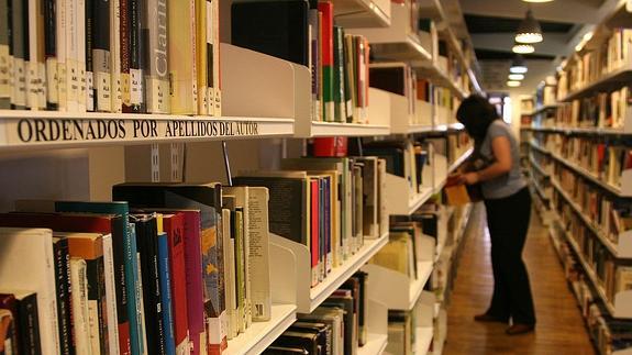 Una usuaria consulta en las estanterías de libro de la biblioteca pública de Segovia. 