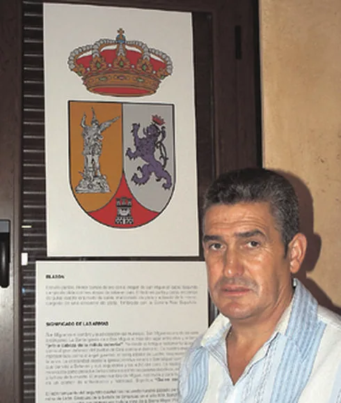 Manuel Oliva junto al escudo de San Miguel de Valero. 