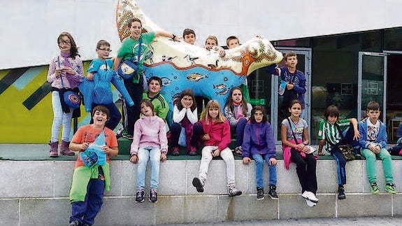 Los alumnos del CRA Las Cañadas posan junto a dos esculturas ‘lambananas. Y. Dulce