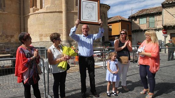 José Enrique Canales alza acompañado de su familia la caricatura tras el nombramiento de Vecino Distinguido. 