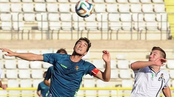 Iván Casado disputa un balón alto con un rival burgalés, 