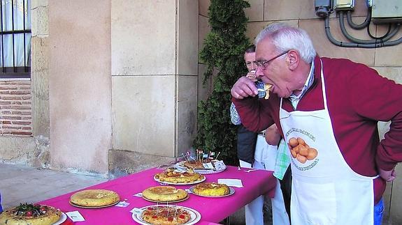 Un miembro del jurado prueba las tortillas presentadas al concurso.