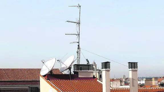 Antenas de televisión y de telefonía móvil, en el tejado de un edificio del centro de la capital palentina. 