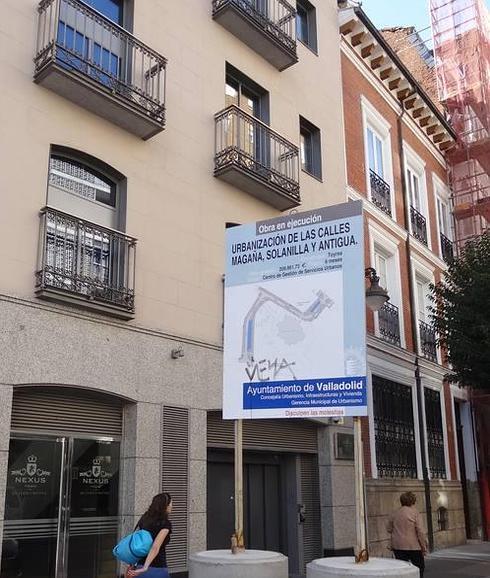 Cartel que corta la acera de la calle Esgueva anunciando obras en los aledaños. 