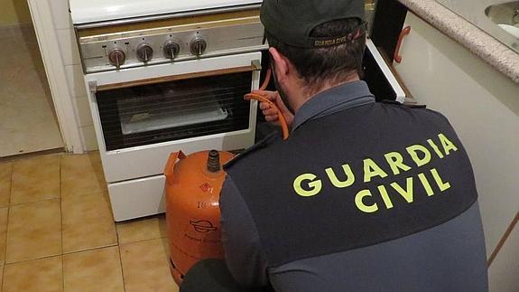 Un guardia civil inspecciona una instalación de gas butano. 