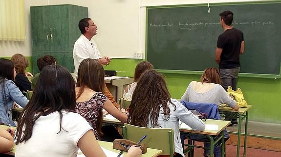 Un profesor dirige el ejercicio de un alumno de Bachillerato en un instituto público de Palencia.