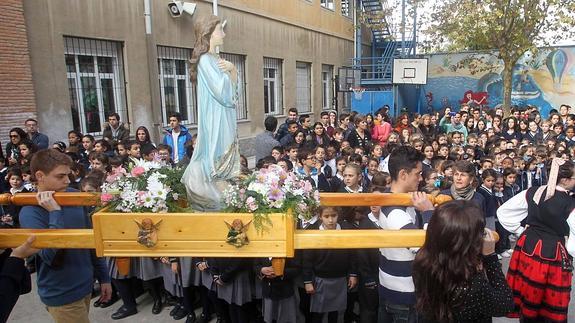 Los alumnos observan el paso de la imagen de la Virgen niña, portada en andas por estudiantes de Bachillerato. Antonio de Torre