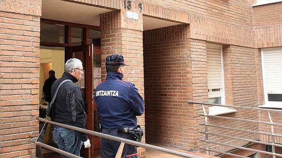 Agentes de la Ertzaintza en el portal de la vivienda de la localidad vizcaína de Abadiño donde aparecieron muertas las dos mujeres.