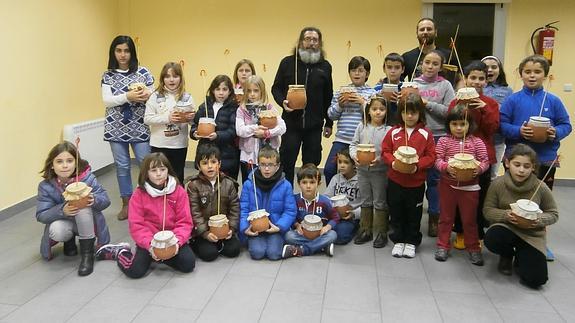 Los niños participantes en el taller de instrumentos musicales posan con las zambombas confeccionadas bajo la dirección de Pablo Zamarrón (centro). Cristina Vega