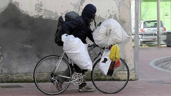 El inquilino, que acumula ya dos desahucios, porta sus enseres en su bici, con la que acude a diario a una chatarrería de Argales. 