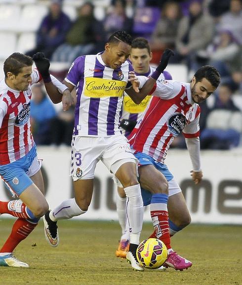 Mojica disputa un balón a dos jugadores del Lugo