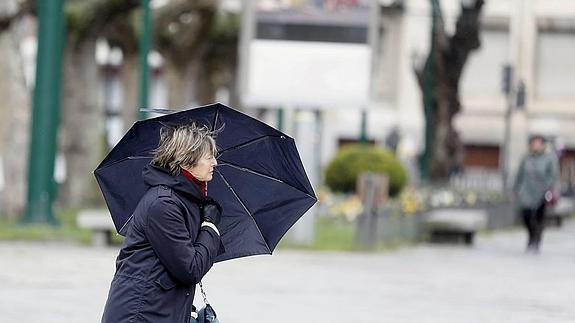 Una mujer se protege del viento en la jornada del martes en Valladolid. 